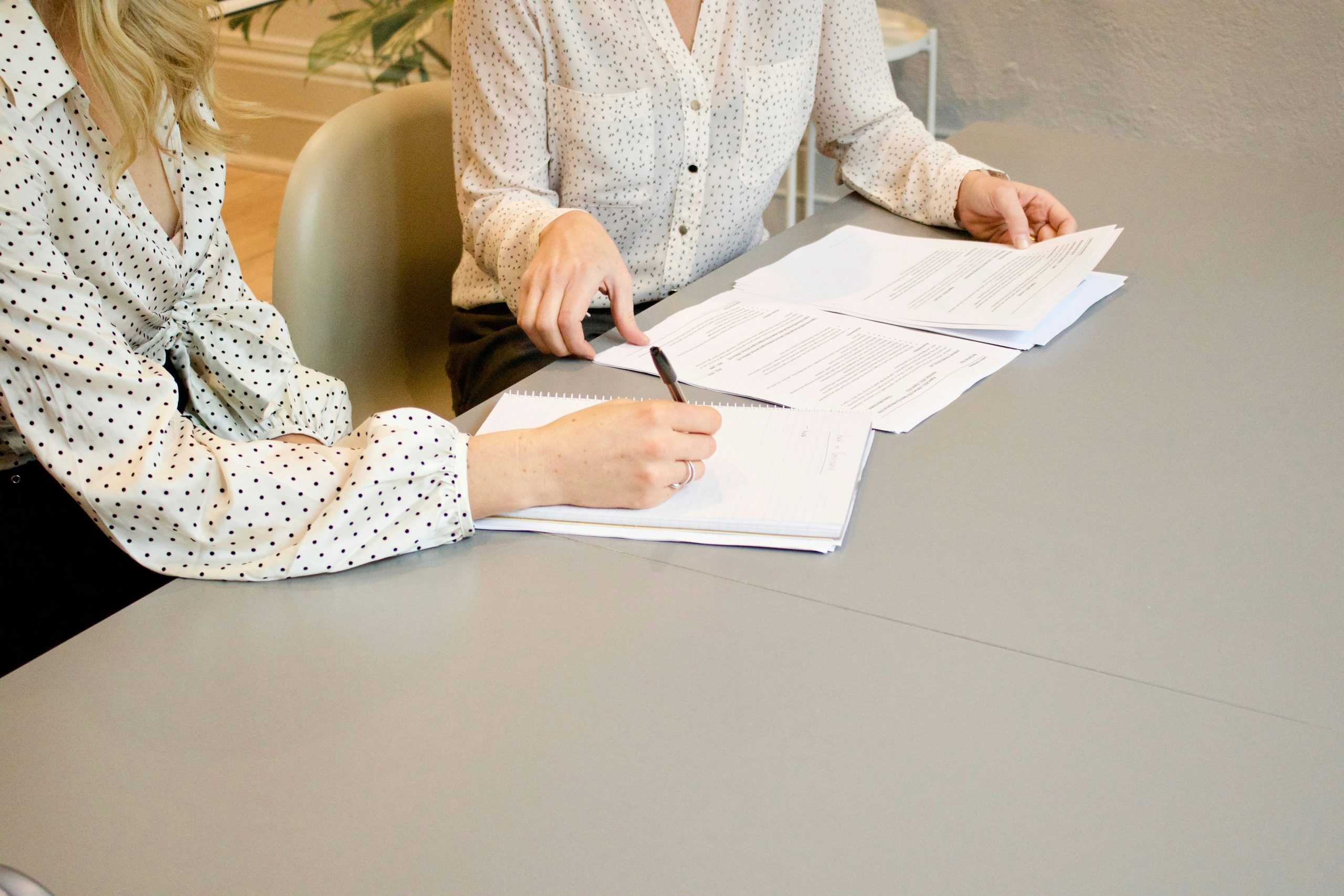 Two people sitting at a table filling out paperwork.
